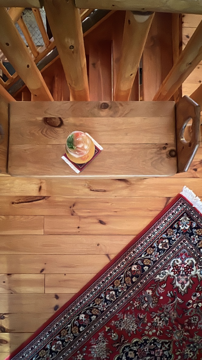 Drink on a carpet coaster beside a patterned carpet